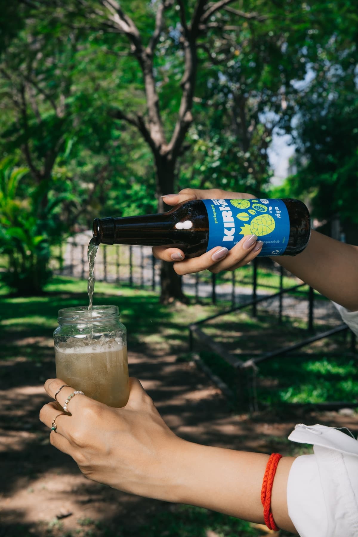 Kiri Kombucha Khmer-language label, poured over ice outdoors